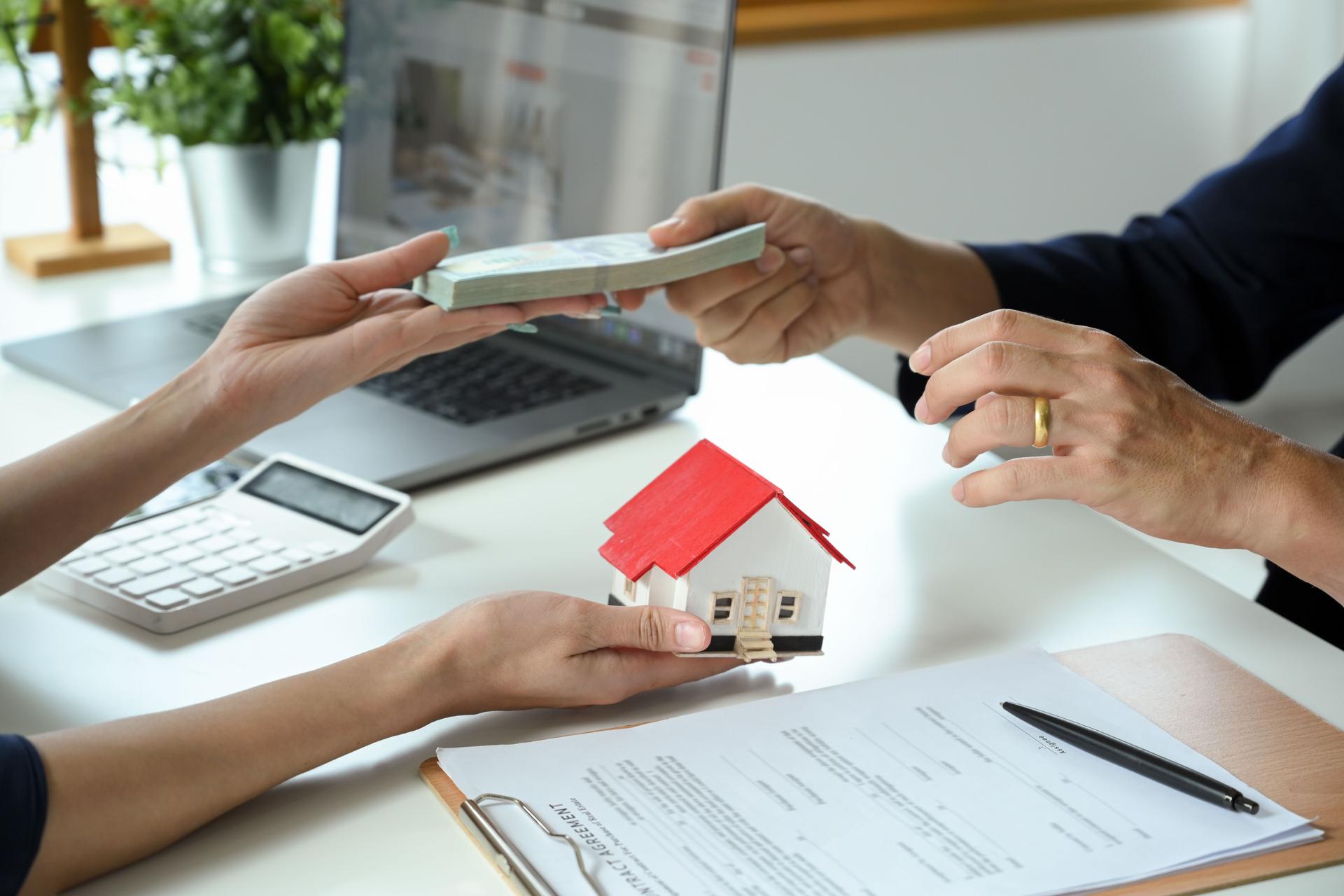 A female real estate agent receives a house loan payment from her client.