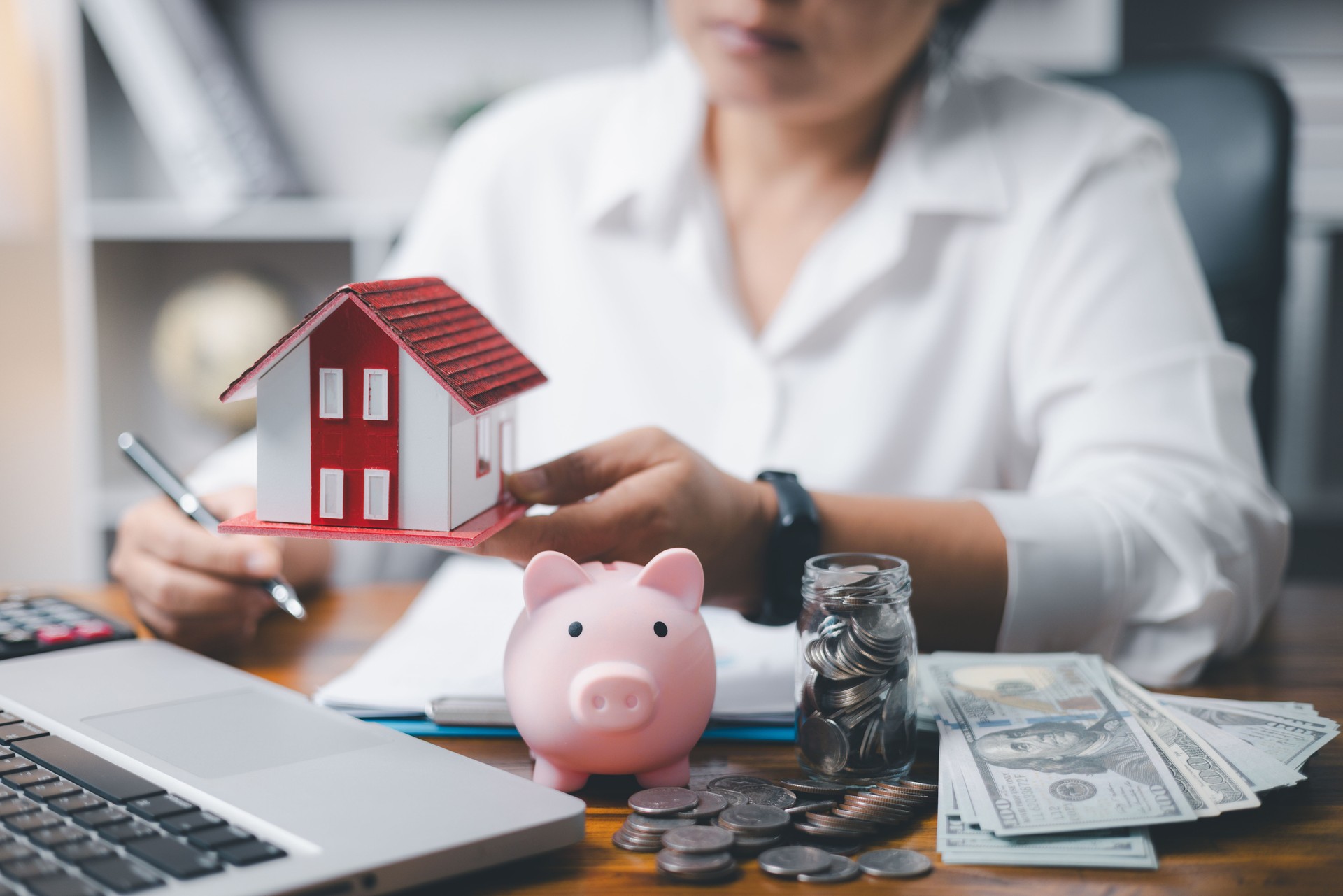 House model and money coins saving for concept saving money for buying a house, investment mortgage finance, and home loan refinance financial plan home. Property insurance and tax money.