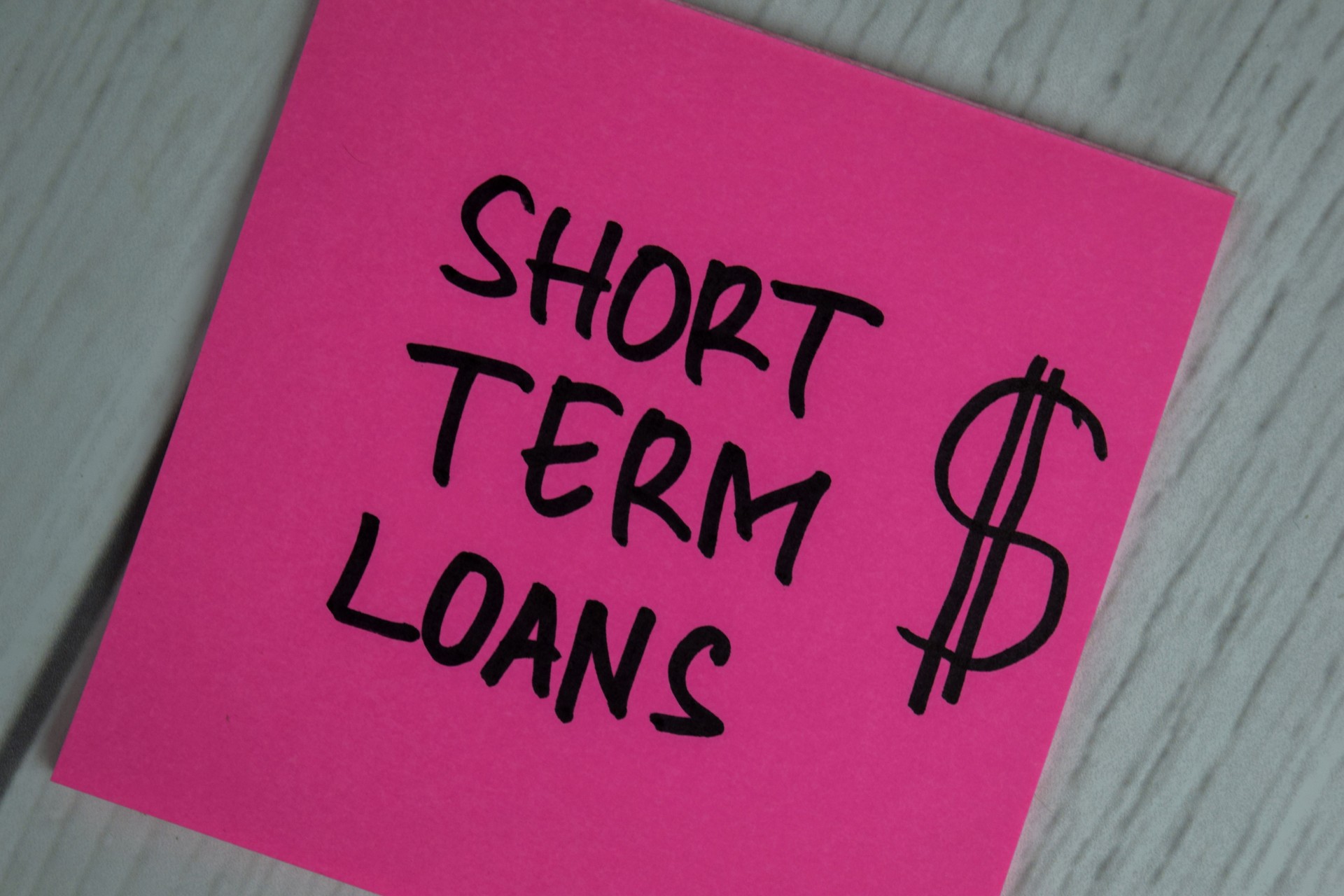 Short Term Loans write on sticky notes isolated on office desk.